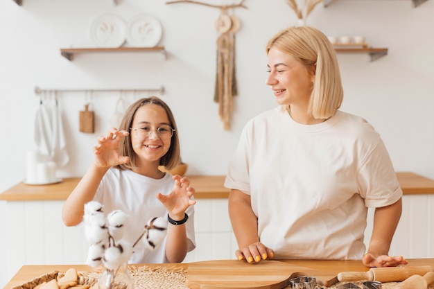 Madre e hija hornean galletas y se divierten en la cocina