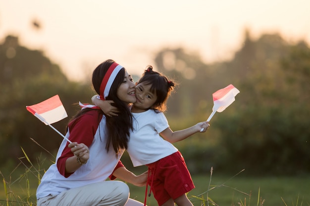 Madre e hija izando la bandera de indonesia