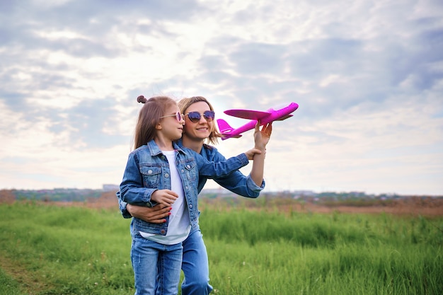 Madre e hija jugando con avión de juguete