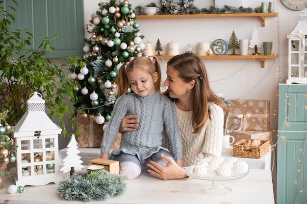 Madre e hija jugando en la cocina de Navidad en casa.