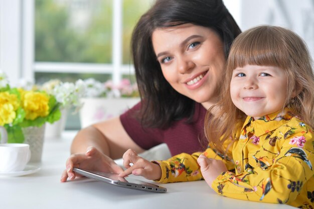 Madre e hija jugando en la computadora portátil