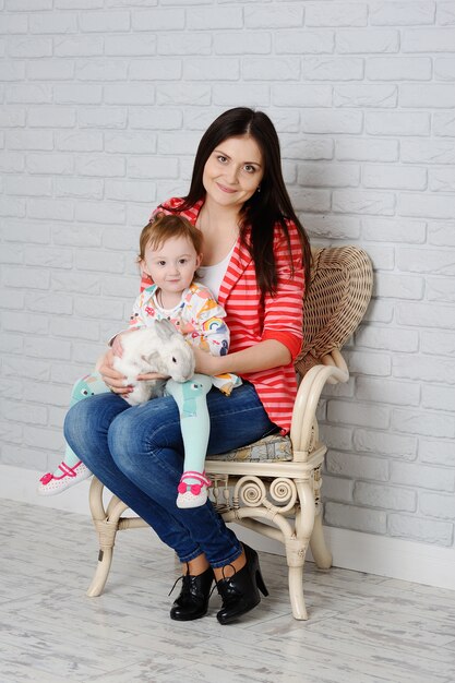 Madre e hija jugando con conejo