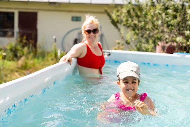 Madre e hija jugando juntas en la piscina de casa