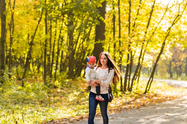 Madre e hija jugando juntos en el parque de otoño.