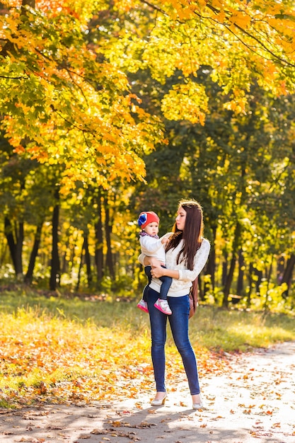 Madre e hija jugando juntos en el parque de otoño.