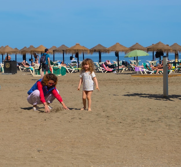 Madre e hija jugando en la playa de la Malagueta