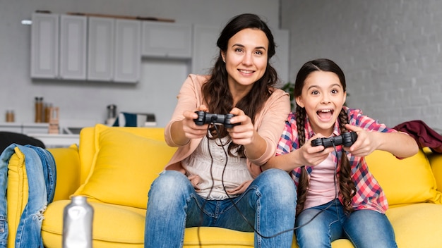 Madre e hija jugando videojuegos juntas