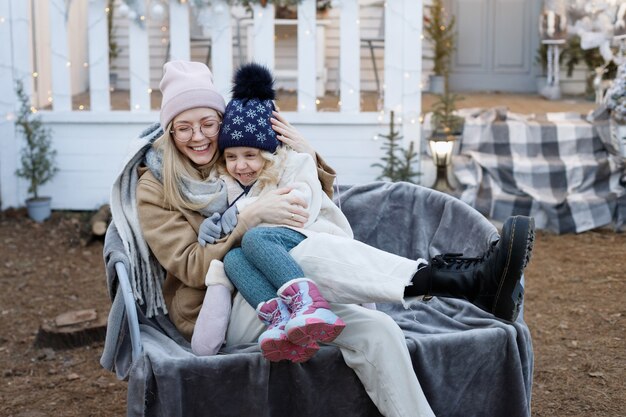 Madre e hija juntas en invierno en el porche