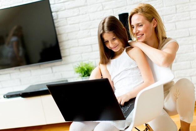 Madre e hija junto con la computadora portátil