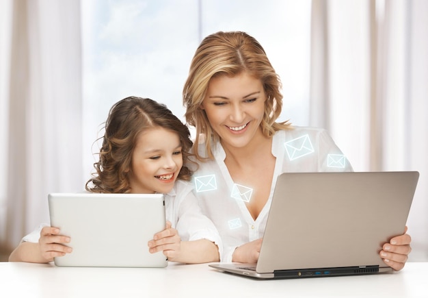 madre e hija con laptop y tablet pc