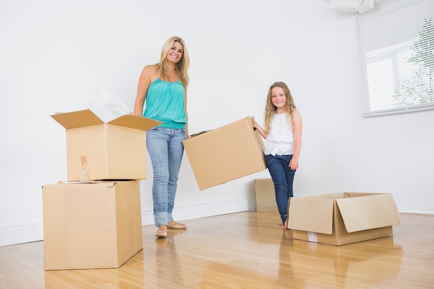 Madre e hija llevando cajas de mudanza