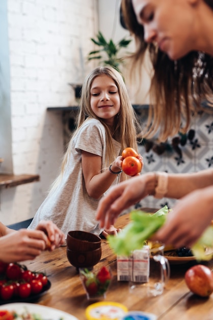 Madre e hija en la mesa de la cocina a punto de comer.