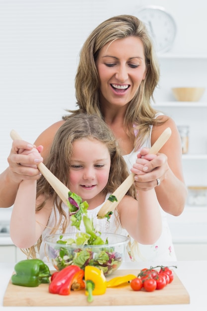 Madre e hija mezclando ensalada