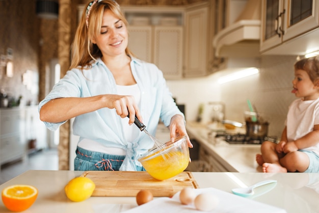 Madre e hija mezclando ingredientes para pastel