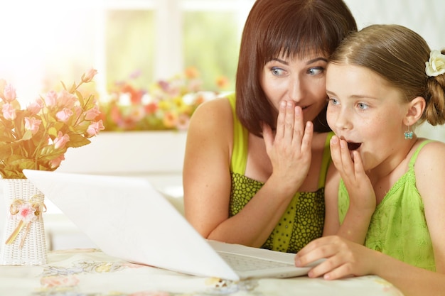 Madre e hija mirando portátil