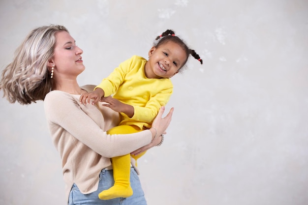 Madre e hija multiétnicas juegan en casa