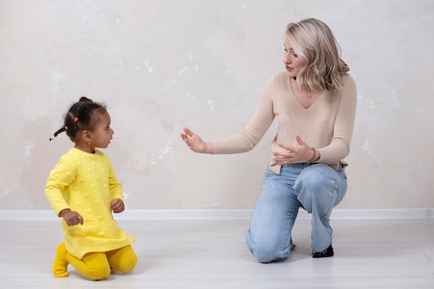 Madre e hija multiétnicas juegan en casa