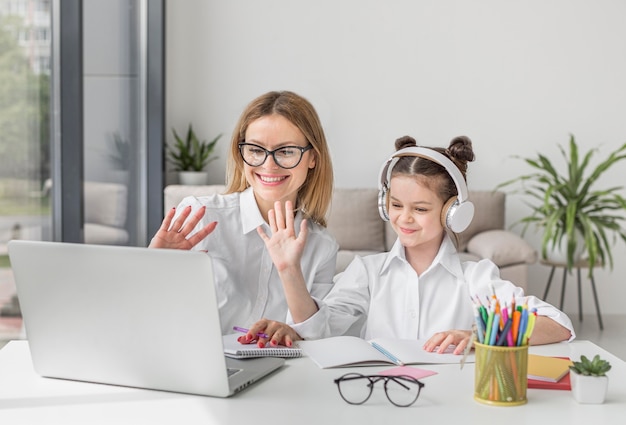 Foto madre e hija participando en una clase en línea.