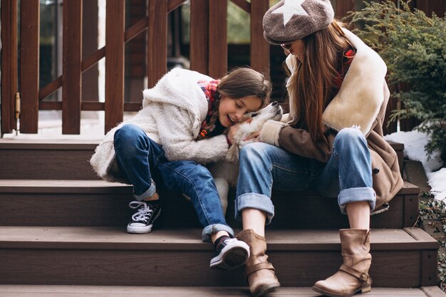 Foto madre e hija con perro afuera