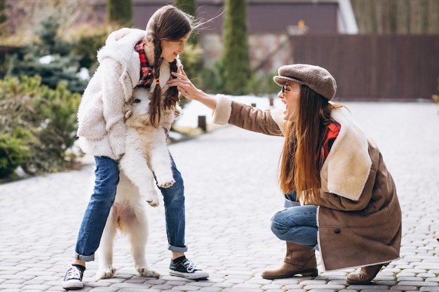 Madre e hija con perro afuera