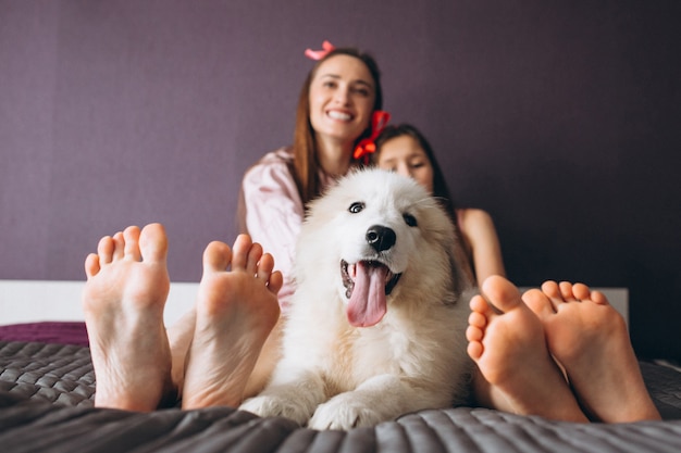 Madre e hija con perro en la cama