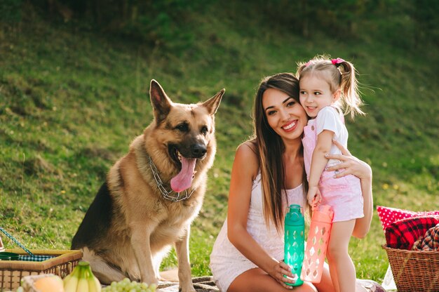 madre e hija en un picnic con un perro