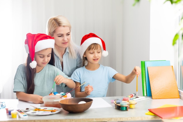 Madre e hija pintando adornos navideños