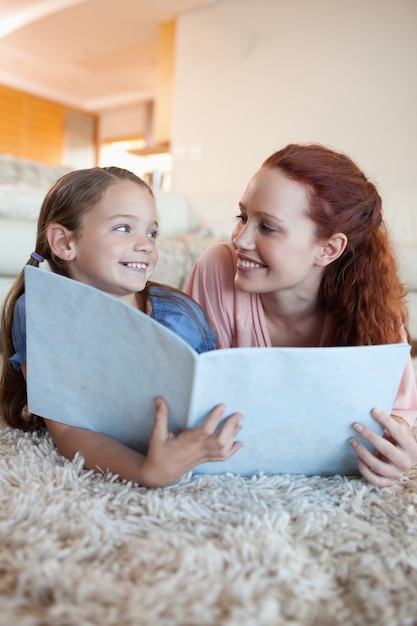 Madre e hija en el piso mirando la revista