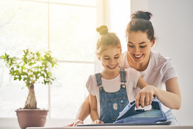 Foto madre e hija planchando en casa