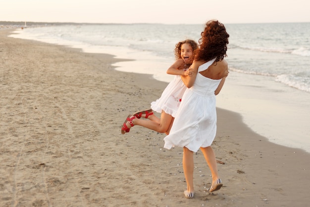 Madre e hija en la playa al atardecer