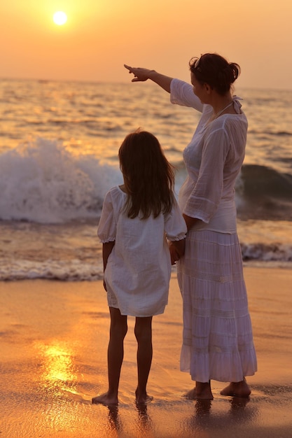 Madre e hija en la playa de arena