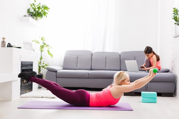 Madre e hija practicando yoga en casa