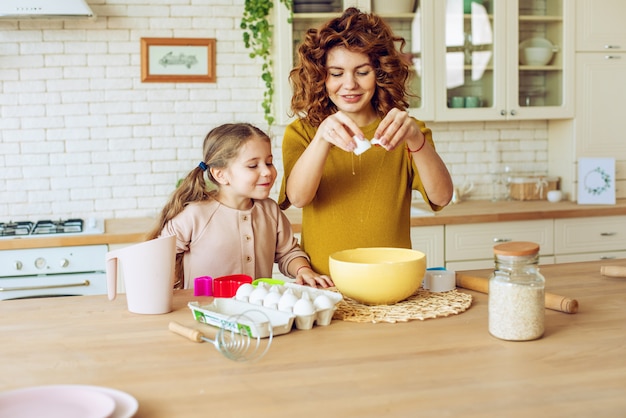 Madre e hija preparan un pastel juntos en la cocina