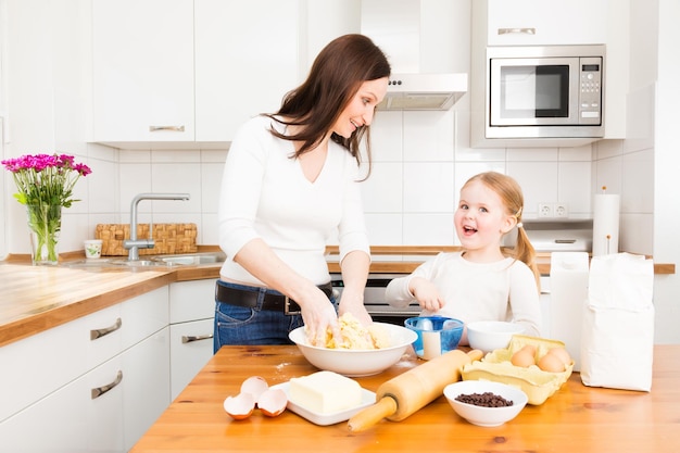 Madre e hija preparando comida en casa