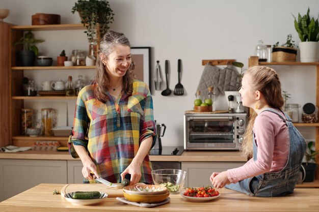 Madre e hija preparando una comida en una cocina moderna