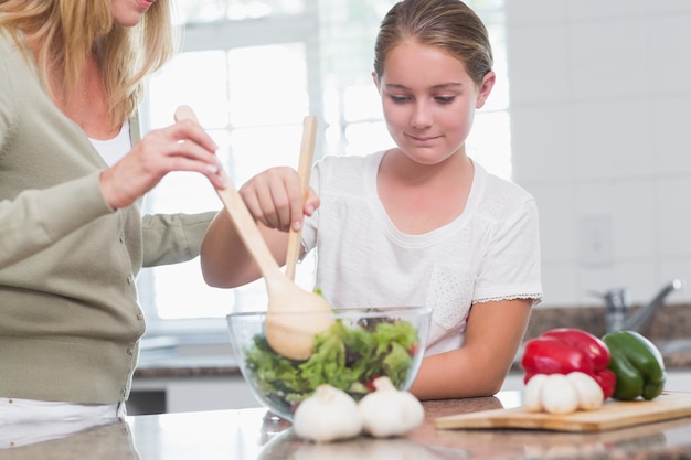 Madre e hija preparando ensalada juntos