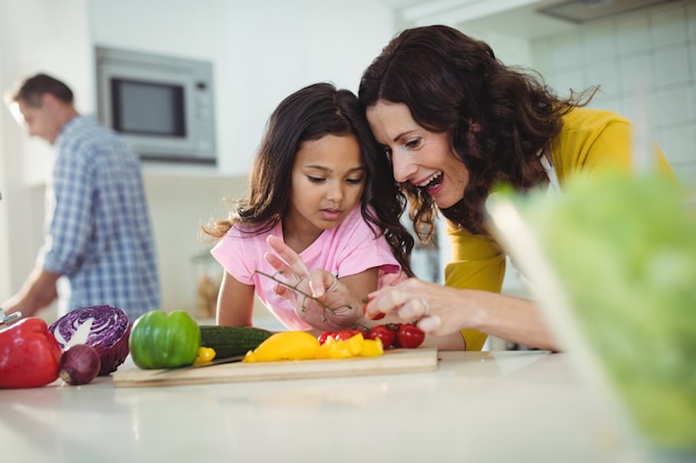 Madre e hija preparando ensaladas en la cocina