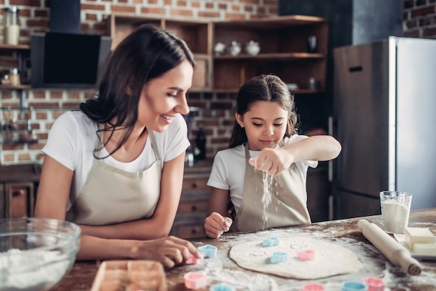 Madre e hija preparando masa para galletas