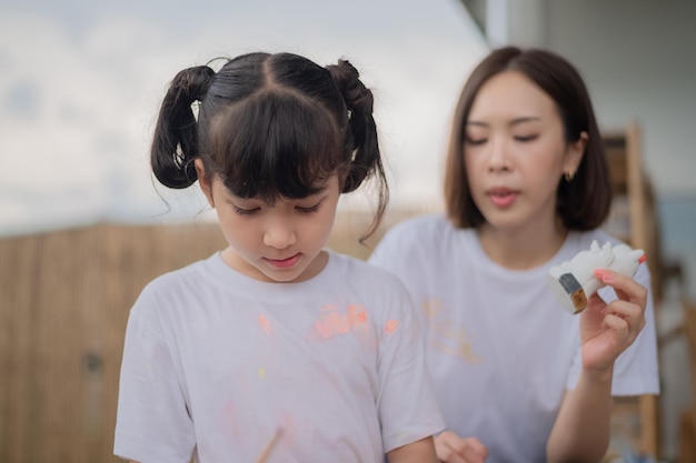 Madre e hija que estudian arte dibujan una muñeca