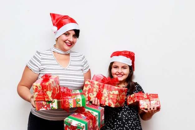 Madre e hija con regalo de Navidad, fondo blanco.