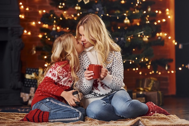 Madre e hija con regalos celebrando juntos las vacaciones de Navidad.