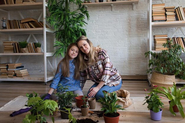 Madre e hija replantando plantas en casa closeup