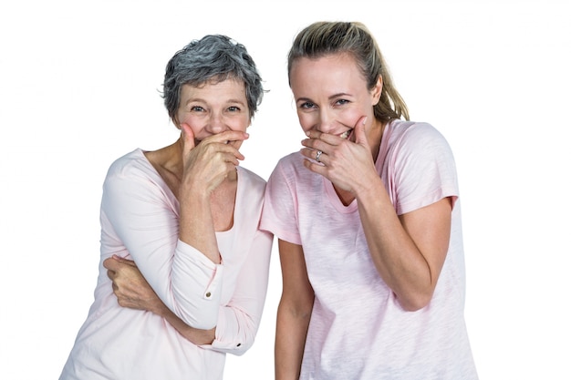 Madre e hija riendo con la mano en la boca