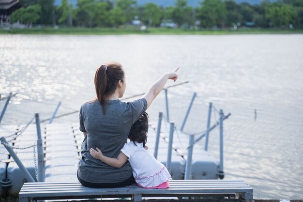 Madre e hija sentadas y mirando al río.