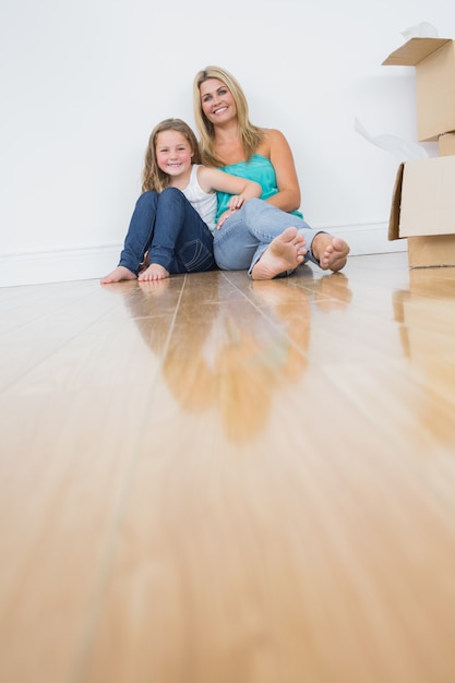 Foto madre e hija sentados en el piso juntos