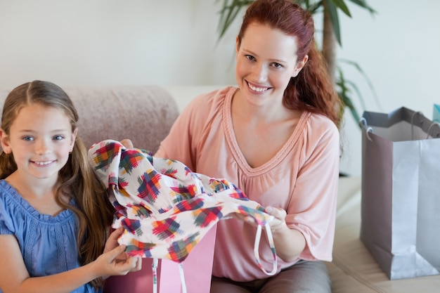 Madre e hija en el sofá con compras