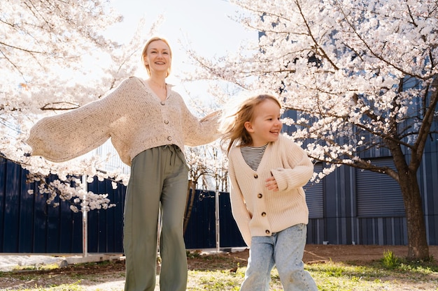 Madre e hija son felices juntos en los árboles en flor jardín frente a la casa Feliz día de la madre