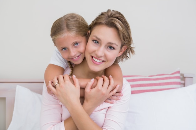 Madre e hija sonriendo a la cámara