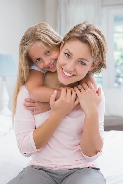 Madre e hija sonriendo a la cámara