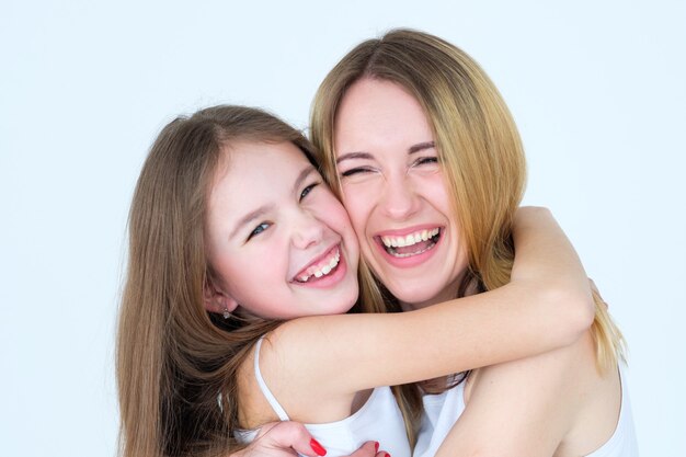 madre e hija sonriendo y riendo juntos abrazándose.